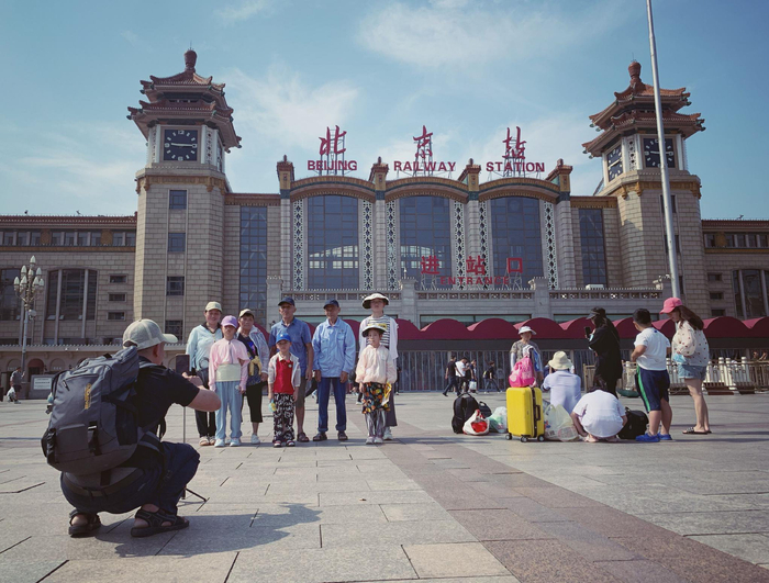 7月2日中午，旅客在北京站前拍摄纪念照。新京报记者 王贵彬 摄