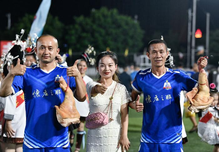 这是在“村超”足球赛现场，球员在展示球队获胜后奖励的猪脚（6月11日摄）。新华社记者 杨文斌 摄