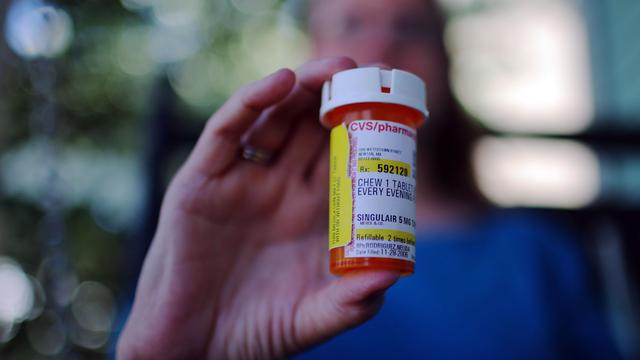 吉尔平手持儿子服用的顺尔宁药物。图片来源：路透社