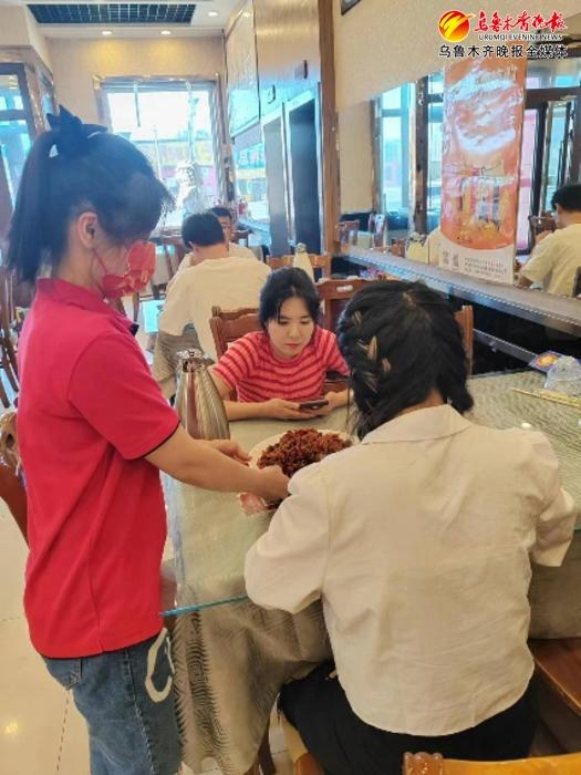 7月3日，在达坂城区柴窝堡辣子鸡一条街金玉兰辣子鸡店，服务员为食客端上美味辣子鸡。记者贾梦妍摄