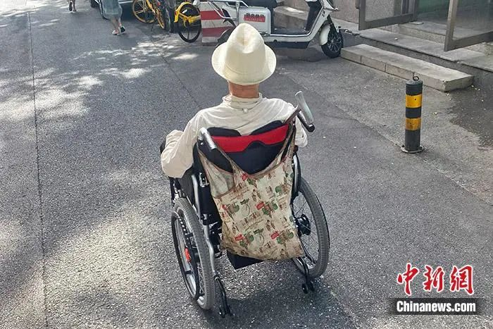 资料图：电动轮椅在道路上行驶。中新财经 葛成 摄