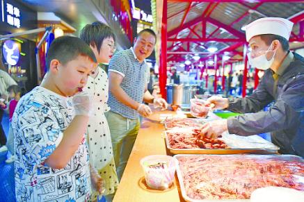 品尝美食。 邓建青/摄