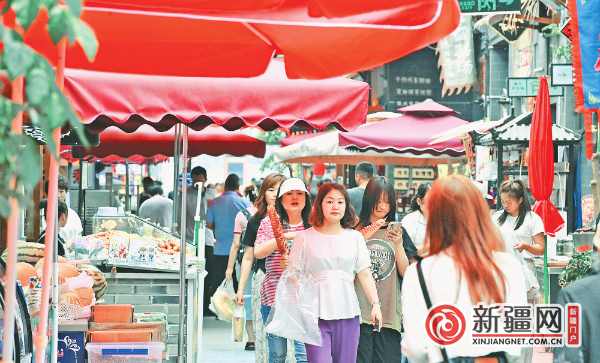 6月29日，游客在乌鲁木齐县闲来小镇宽窄巷子文旅步行街休闲漫步品美食。（全媒体记者陈岩摄）