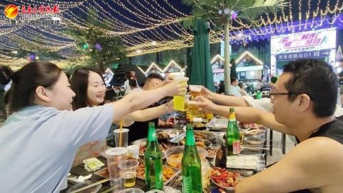 7月7日晚，在野马时光文体创意园夜市，游客正在品尝美食。记者牟敏摄