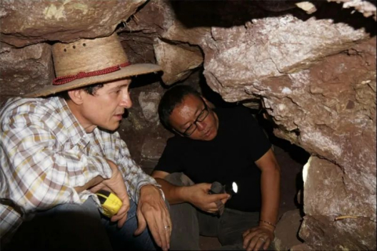 李新伟（右）与洪都拉斯考古工作者在隧道内讨论建筑演变。