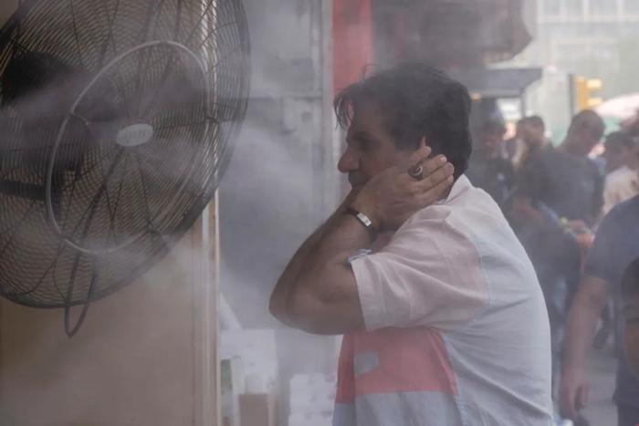 当地时间7月6日，伊拉克巴格达，一名男子在露天淋浴中降温。视觉中国供图