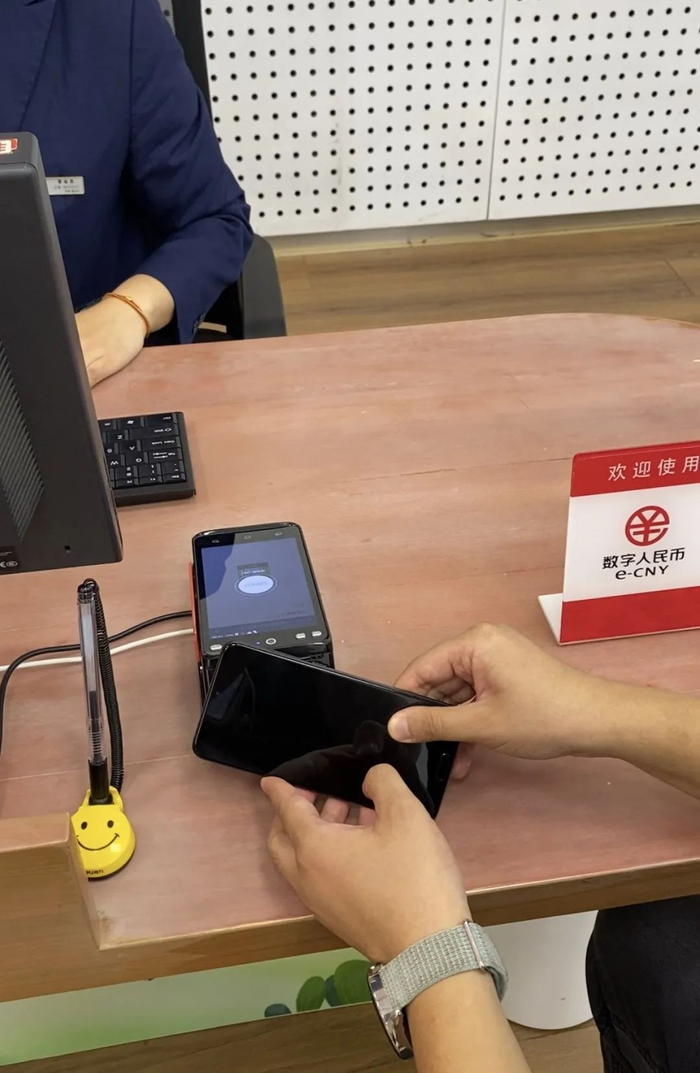 工作人员演示在无电情况下进行数字人民币SIM卡硬钱包支付。