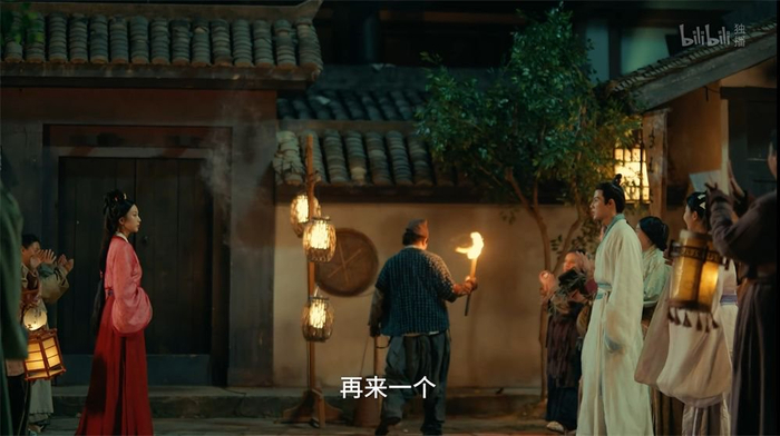 《古相思曲》截图，站在杂耍艺人两端的男女主