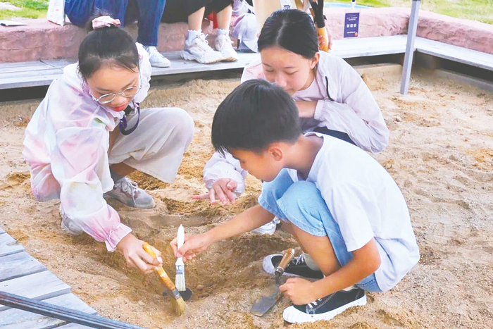     学生们在顶蛳山遗址博物馆体验模拟考古。