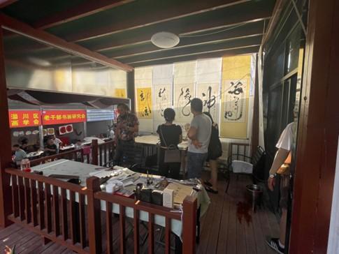淄博八大局字画一条街，邀请各地的字画专家们到街头画扇面、写书道。