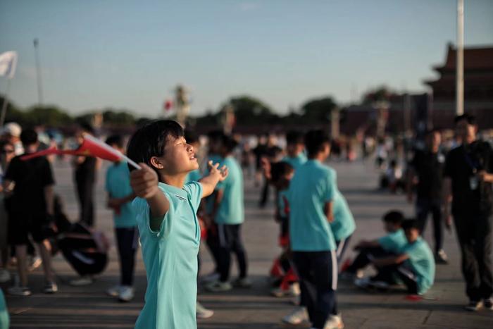 7月10日，夏令营临近结束，孩子们在天安门广场观看了升旗仪式。仪式结束后，一个女孩张开双臂迎接朝阳。新京报记者 王嘉宁 摄