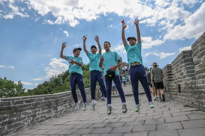 ▲7月9日，贵州省黔西南州青少年足球队队员们在长城上高高跃起。  新京报记者 王子诚 摄