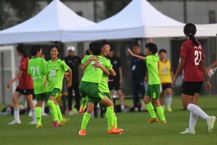 7月5日，贵州省黔西南州青少年足球队与北京青少年队的友谊赛中，进球后徐佳佳与队友相拥欢呼。新京报记者 王颖 摄