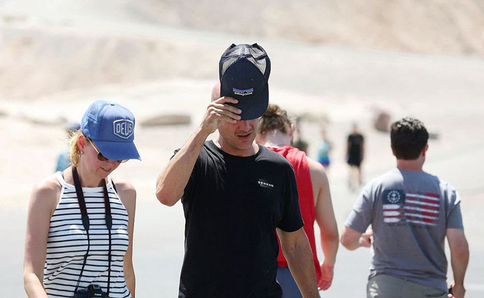 当地时间2023年7月16日，美国加州，死亡谷国家公园，游客在热浪中走回他们的车里。