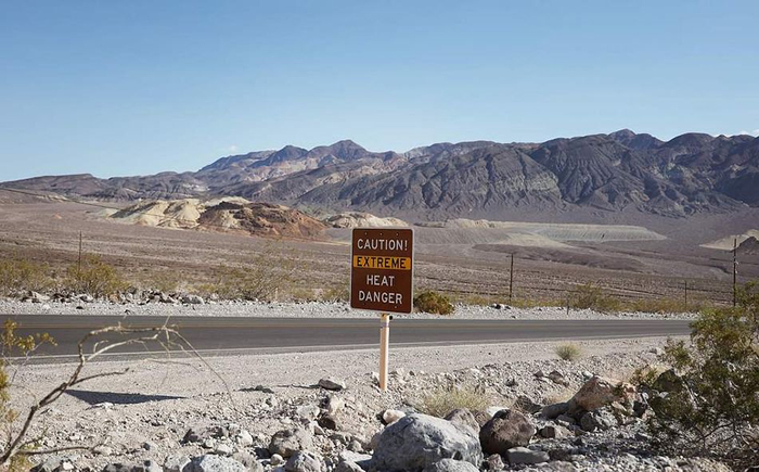 当地时间2023年7月16日，美国加州，死亡谷国家公园，热浪袭来，美国190号高速公路上的高温警告标志。