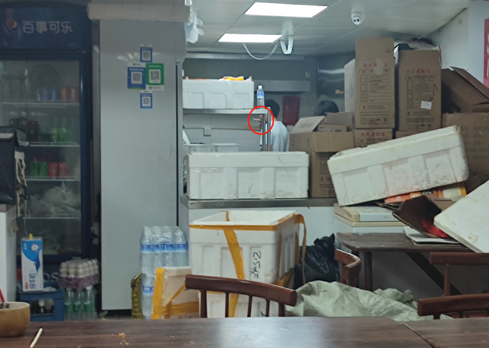 岳各庄桥东南侧一家美食城，一家平台上没有照片的烧烤店，门口杂物堆积，厨师还在抽烟