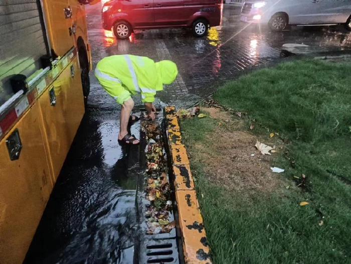▲抢险人员正冒雨疏通路段积水。受访者供图