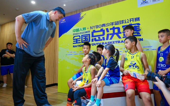 中国篮协主席姚明（左）与小球员交流。  主办方供图