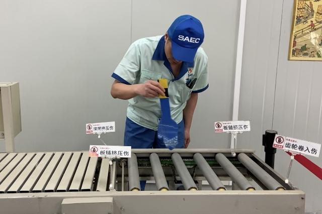 任继军在流水线演示机上展示错误操作的风险。本文图片均为 澎湃新闻记者 陈悦 图