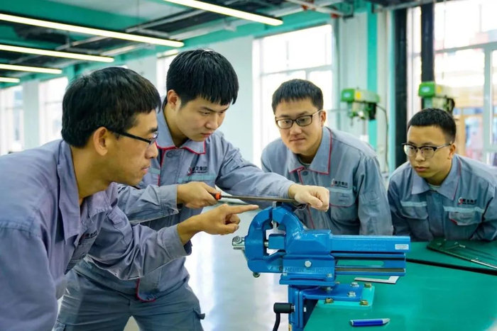 抚顺新钢铁技能实训中心里，讲师吕亮（左一）正在开展钳工实操培训。受访者供图