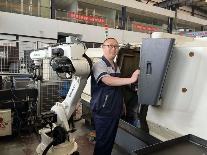 如今，通过编程与机械臂协同工作已是张宇峰上班时的日常。李晶 摄