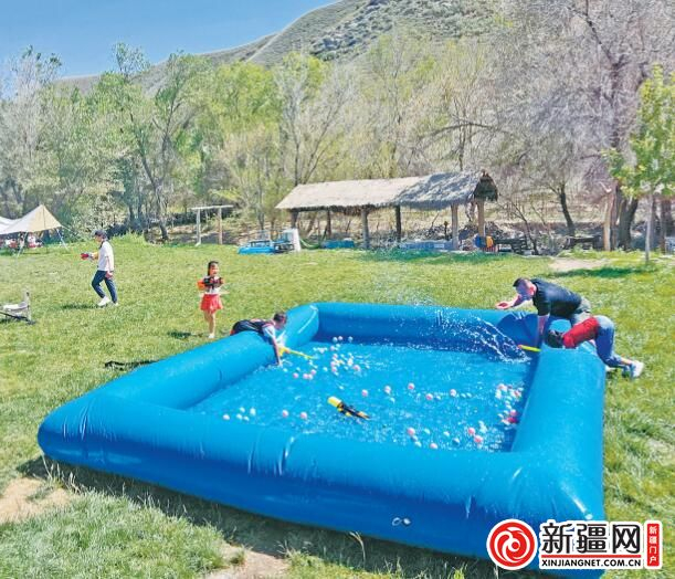 在柏杨河哈萨克乡的溪畔庄园山庄，游客正在嬉水娱乐。 （全媒体记者宋建华摄）