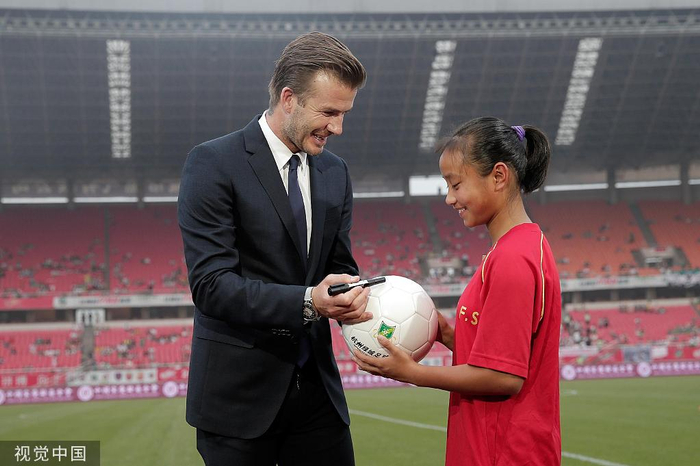 2013年，贝克汉姆给张琳艳送上签名足球。