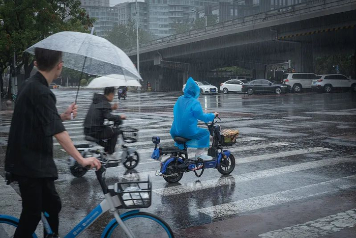7月30日，北京市朝阳区，市民冒雨出行 （视觉中国）