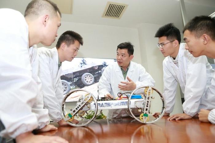 国防科技大学智能科学学院无人作战系统科技创新团队科研人员在实验室探讨设计方案(2020年10月19日摄)。新华社发(何书远 摄)