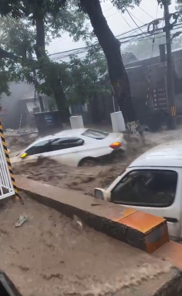 7月31日，北京门头沟地区河水上涨，汽车被冲走。@法治进行时 视频截图