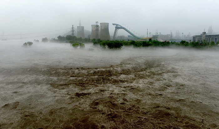 2023年8月1日，北京永定河上游，凶猛的泄洪顺利通过石景山区莲石湖段，远处是首钢大跳台。