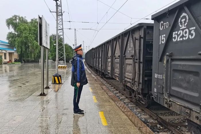 图为新朔铁路员工进行雨中接车作业