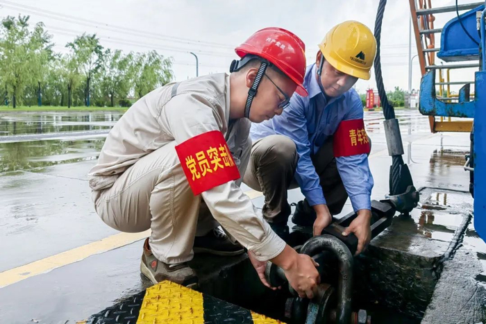 图为江苏公司党员突击队正在执行卸船机防风措施
