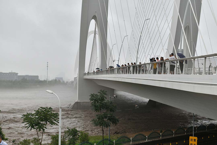 2023年8月1日，北京，永定河波涛汹涌，洪水奔流穿过首钢大桥。