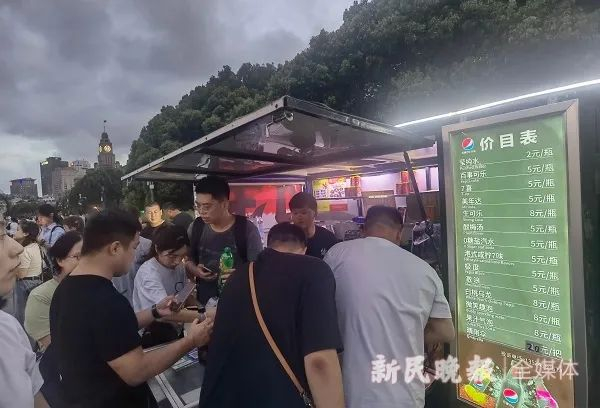 游客扎堆到外滩饮料流动服务车前，不一定能如愿买到水。  本文图均为 新民晚报 图