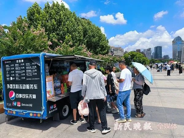新一天运营不久，游客便聚到外滩饮料流动服务车前购买。