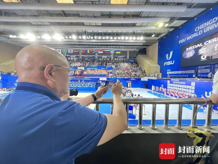 陈爱平正全神贯注为女儿录像