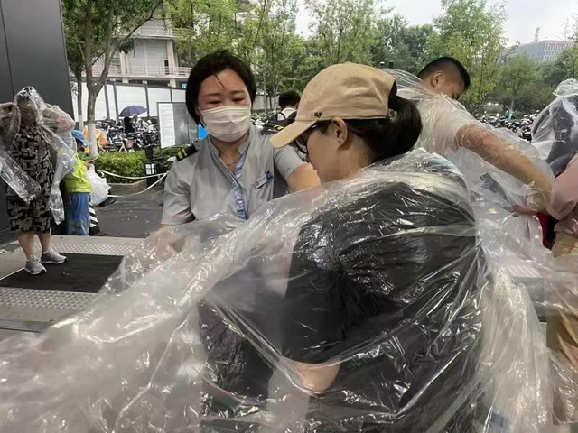 地铁工作人员发放雨衣 北京地铁公司供图