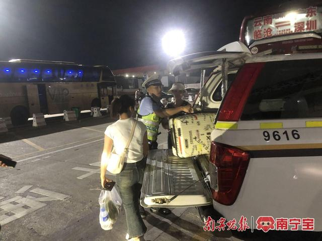 民警接过两名女子的行李放置到警车中，并驾驶警车将两名女子送至贵港高铁站