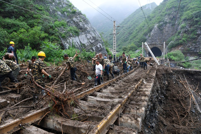 8月1日，在北京市门头沟区水峪嘴村附近一段被阻断的铁路线上，中铁六局的工作人员在清理轨道上的杂物，全力恢复交通。
