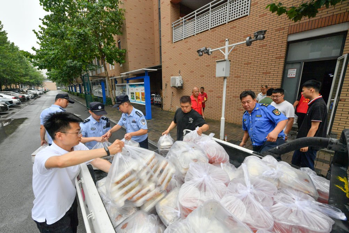 8月1日，在天津市武清区职业教育中心临时安置点，多部门工作人员为转移人员准备午饭。