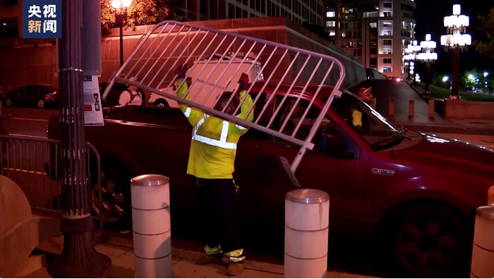 当地时间2日晚，在美国首都华盛顿特区特朗普即将出庭的联邦法院外，工作人员安装了防护围栏。 央视新闻报道视频截图