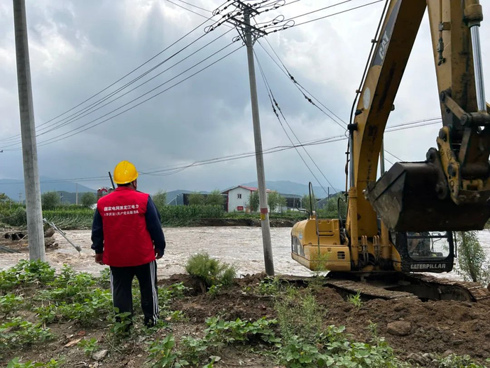 8月4日，国网尚志供电公司亚布力供电所郑文君、王立军在亚布力镇下八里屯为被洪水冲刷的杆塔进行杆基加固。 刘铁 摄