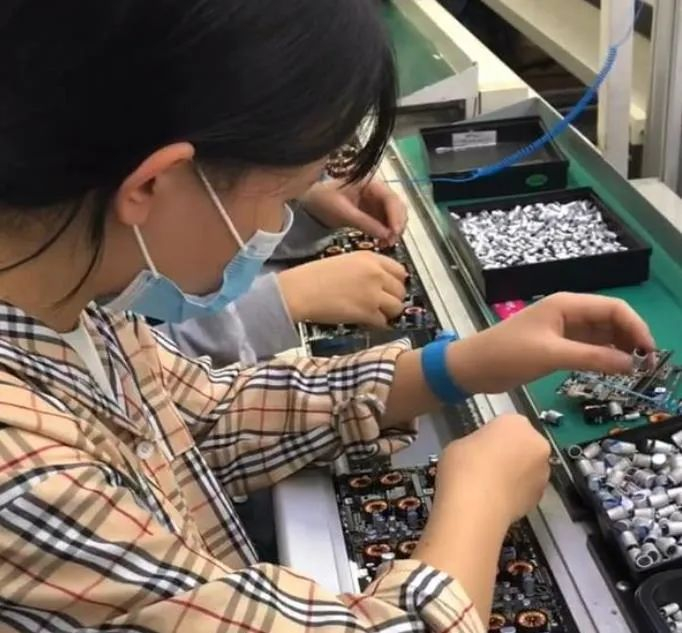 ▲电子厂生产车间流水线上的工人，图片来自网络。