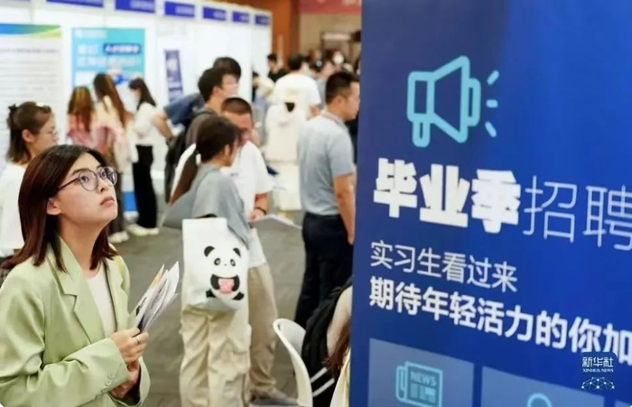 ▲求职者在高校毕业生就业招聘会上了解信息。图/新华社