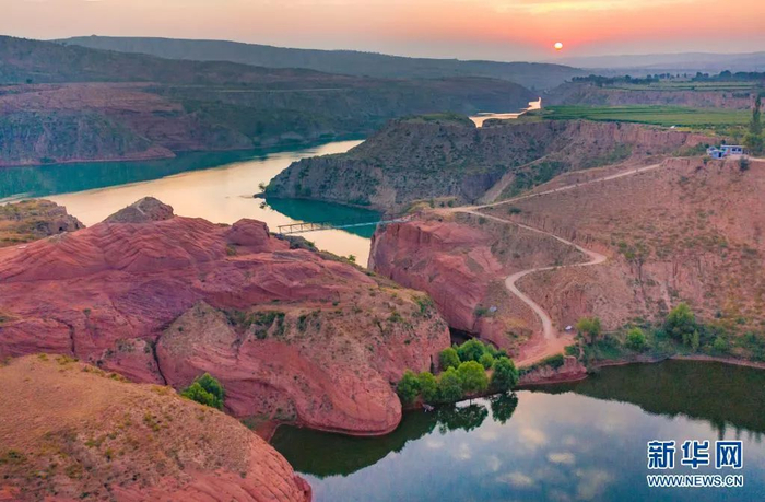 朝霞映照下的靖边县龙洲镇波浪谷丹霞景区（无人机照片）。新华社记者 陶明 摄