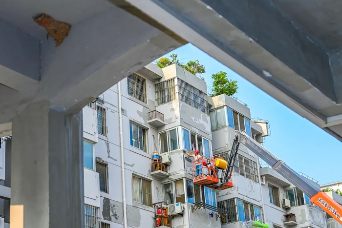 6月30日，在江苏省宿迁市宿城区幸福街道一个老旧小区里，工人正对外墙进行施工作业。陈少帅摄（中经视觉）