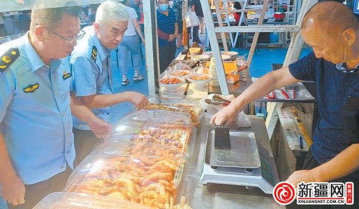 8月7日21时许，在沙依巴克区五一星光夜市，市场监管部门执法人员正在检查商户的电子秤。 （全媒体记者王璇摄）