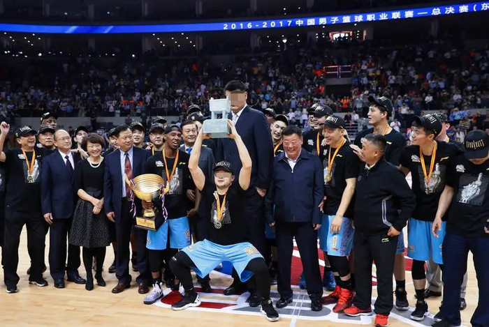 ▲篮协主席姚明为新疆队颁发冠军鼎，西热力江搞怪举鼎