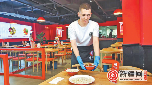 8月10日，在库大叔拌面八道湾店，店员为顾客端上19元的过油肉拌面。（全媒体记者王璇摄）